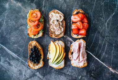 Kahvaltı, öğle yemeği ya da atıştırmalık için lezzetli sağlıklı tostlar, koyu mermer arka plan.