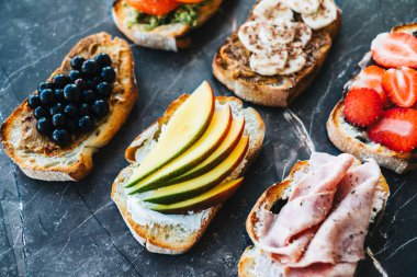 Kahvaltı, öğle yemeği ya da atıştırmalık için lezzetli sağlıklı tostlar, koyu mermer arka plan.