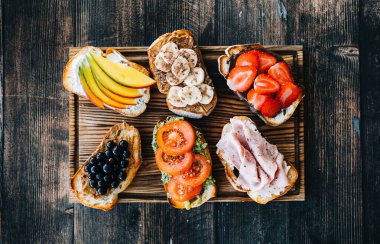 Lezzetli sağlıklı tostlar kahvaltı, öğle yemeği ya da atıştırmalıklar ellerinde tahta bir tahtanın üzerinde..