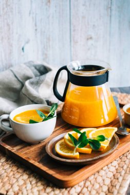 Çaydanlıkta demlenmiş deniz dikenli çay, portakallı, cam bardaklı taze portakal, nane ve bal..