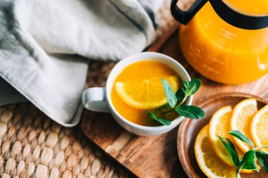 Çaydanlıkta demlenmiş deniz dikenli çay, portakallı, cam bardaklı taze portakal, nane ve bal..