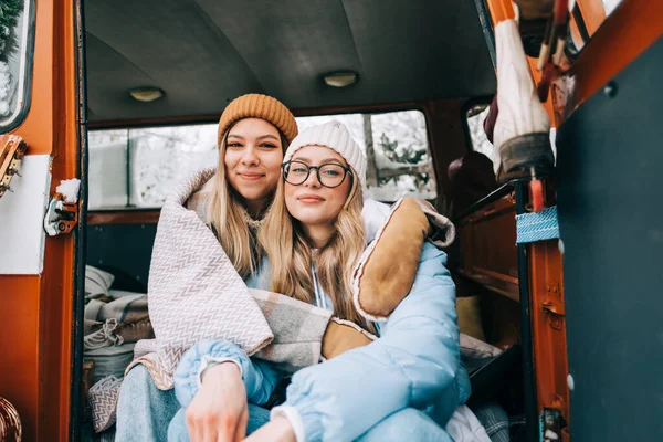 两个快乐的年轻女性朋友坐在冬季营房的面包车里的画像 — 图库照片