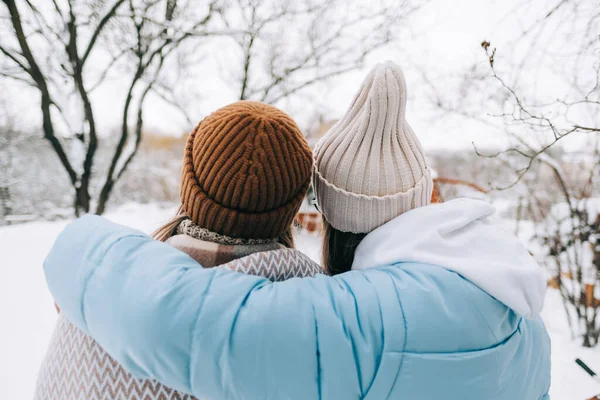 两个姐姐站在后院里拥抱着 在冬天的早上下了雪之后环顾四周 — 图库照片