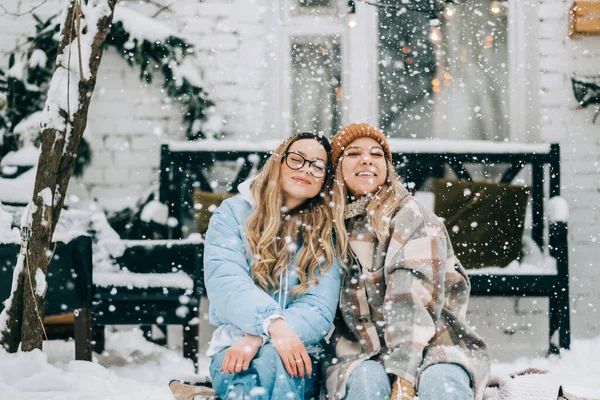 两个快乐的女性朋友降雪后坐在后院的肖像 享受着冬天的时光 — 图库照片