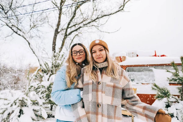 冬のキャンプの雪の間にバンの近くに屋外に立つ2人の陽気な女性の友人の肖像画 — ストック写真