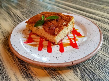 Kafedeki bir masada krema ve nane yaprağıyla taze pişmiş sünger kek.