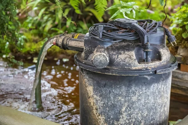 Bahçedeki ya da bahçedeki çiçekleri sulamak için kullanılan eski metal musluk.