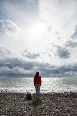 Deniz ve bulutların arkasındaki kadın. Arkadan bak..