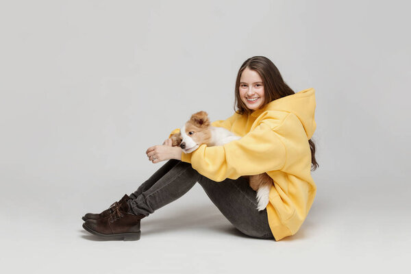 A young woman holds a puppy in her arms.