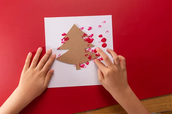 Arbre de Noël abstrait, bricolage d'empreintes digitales, les mains des enfants faisant carte de vœux sur fond rouge — Photo