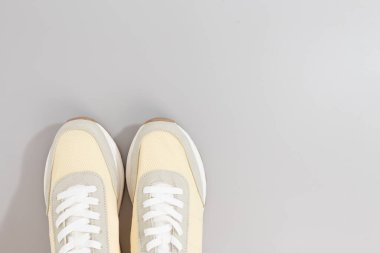 Gri arkaplanda klasik açık renk spor ayakkabıları