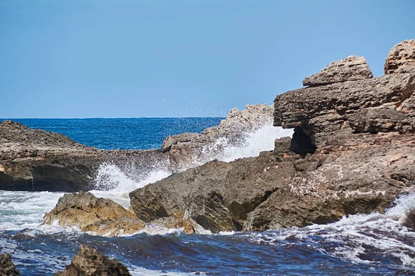 Kameny na břehu zasažené vlnou — Stock fotografie