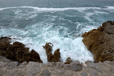 Çakıl taşlı bir yolda dalgalar kıyıya vuruyor. Su köpüğü, vahşi sular, doku, okyanus, deniz, kayalar, tehlike