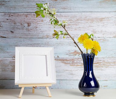 bahar çiçekli elma dalı ve mavi vazoda karahindibalar ve kare beyaz çerçeve, seçici odaklanma için. Yüksek kalite fotoğraf