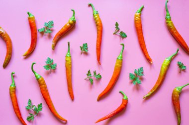 Kırmızı acı biber deseni ve pembe arka planda maydanoz.