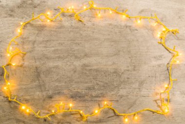 christmas lights frame with copy space on wooden background .