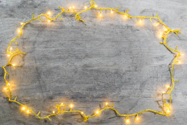 christmas lights frame with copy space on wooden background .