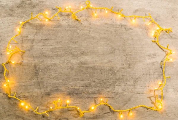 christmas lights frame with copy space on wooden background .