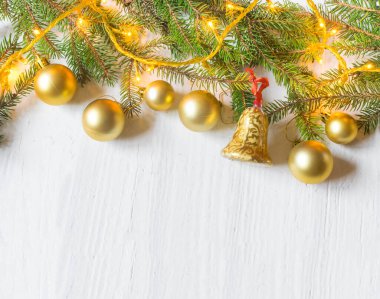 Beautiful christmas decoration (baubles, lights, pine branches) on old white, wooden background. Place for text included