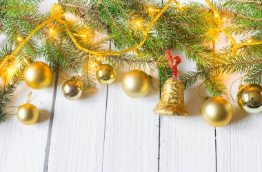 Beautiful christmas decoration (baubles, lights, pine branches) on old white, wooden background. Place for text included