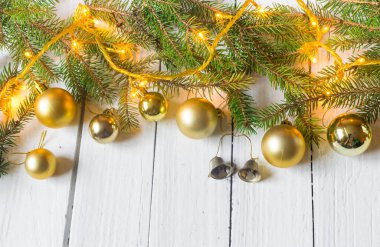 Beautiful christmas decoration (baubles, lights, pine branches) on old white, wooden background. Place for text included