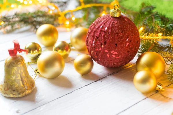 Beautiful christmas decoration (baubles, lights, pine branches) on old white, wooden background. Place for text included