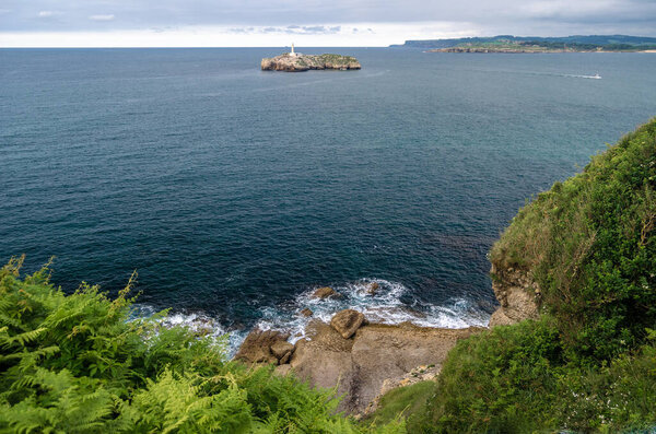 View of Mouro Island (Isla de Mouro), a small uninhabited island with a 19th century lighthouse in the Bay of Biscay, located off the Magdalena Peninsula in the city of Santander, Cantabria, northern Spain