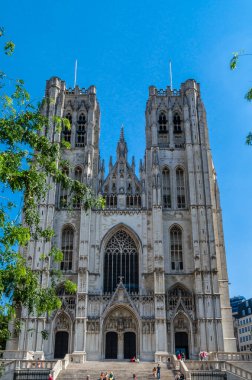 BRÜKSEL, BELGIUM - 21 AĞUSTOS 2013: Brüksel, Belçika 'daki katedralin girişindeki merdivenlerde oturan insanlar