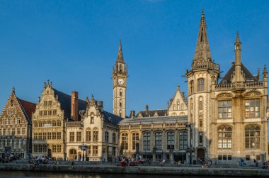 GHENT, BELGIUM - 20 AĞUSTOS 2013: Şehir manzarası, insanlar Ghent, Belçika 'nın tarihi şehir merkezinde bir rıhtım olan Graslei' de güzel bir yaz öğleden sonranın tadını çıkarıyorlar. Ortaçağ limanının bir kısmı şu anda şehrin kültürel ve turistik merkezidir.