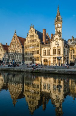 GHENT, BELGIUM - 20 AĞUSTOS 2013: Şehir manzarası, insanlar Ghent, Belçika 'nın tarihi şehir merkezinde bir rıhtım olan Graslei' de güzel bir yaz öğleden sonranın tadını çıkarıyorlar. Ortaçağ limanının bir kısmı şu anda şehrin kültürel ve turistik merkezidir.