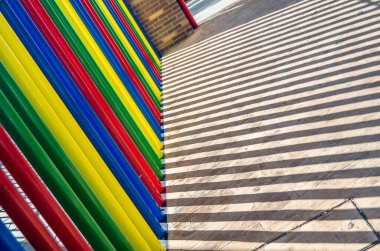 Renkli bir çit ve gölgesi görünüyor.