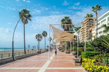ESTEPONA, İspanya - 12 Ekim 2021: Güney İspanya 'nın Malaga eyaleti Costa del Sol' da bir kasaba olan Estepona 'nın kıyı şeridinde gezinen insanlar