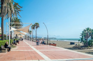 ESTEPONA, İspanya - 12 Ekim 2021: Güney İspanya 'nın Malaga eyaleti Costa del Sol' da bir kasaba olan Estepona 'nın kıyı şeridinde gezinen insanlar