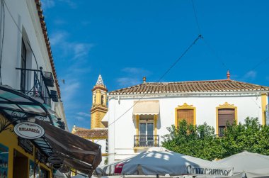 ESTEPONA, İspanya - 12 Ekim 2021: Estepona 'nın merkezinde dar sokaklar, tipik Endülüs kasabası, Costa del Sol, güney İspanya' da bulunan renkli saksılarla süslenmiş beyaz evler