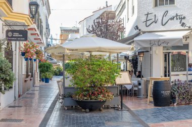 ESTEPONA, İspanya - 12 Ekim 2021: Estepona 'nın merkezinde dar sokaklar, tipik Endülüs kasabası, Costa del Sol, güney İspanya' da bulunan renkli saksılarla süslenmiş beyaz evler