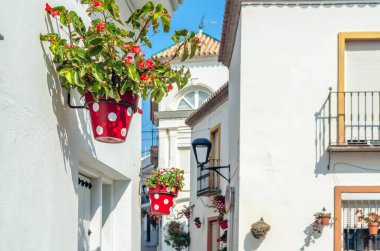Estepona 'nın merkezinde dar sokaklar, tipik Endülüs kasabası, İspanya' nın güneyindeki Costa del Sol eyaletinde bulunan renkli saksılarla süslenmiş beyaz evler.