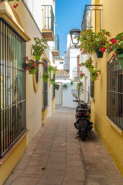 Estepona 'nın merkezinde dar sokaklar, tipik Endülüs kasabası, İspanya' nın güneyindeki Costa del Sol eyaletinde bulunan renkli saksılarla süslenmiş beyaz evler.