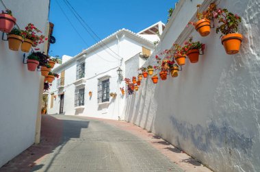 Estepona 'nın merkezinde dar sokaklar, tipik Endülüs kasabası, İspanya' nın güneyindeki Costa del Sol eyaletinde bulunan renkli saksılarla süslenmiş beyaz evler.