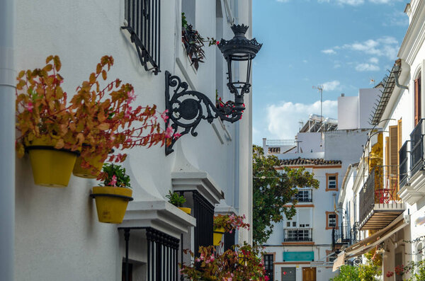 Narrow streets in the center of Estepona, typical Andalusian town, with white houses adorned with colorful flower pots located on the Costa del Sol, Malaga province, southern Spain