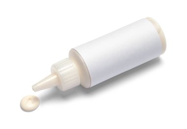 Küçük tahta yapıştırıcı şişesi devrildi ve beyaza damladı.