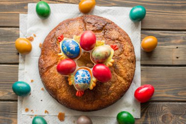 Kozunak 'ın üst görüntüsü (geleneksel Paskalya ev yapımı tatlı Bulgar ekmeği) ve ahşap bir masa üzerinde renkli yumurta çemberi