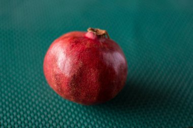 Yeşil bir yemek platformunda kırmızı sulu nar.