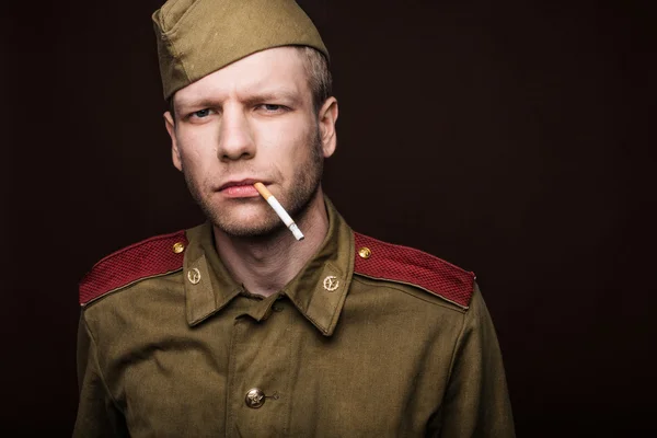 Soldado russo fumando cigarro e olha para algo — Fotografia de Stock