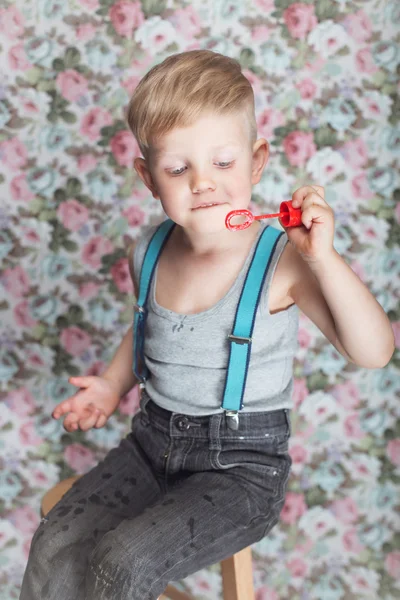 Hermoso niño rubio alegre soplando burbujas de jabón — Foto de Stock