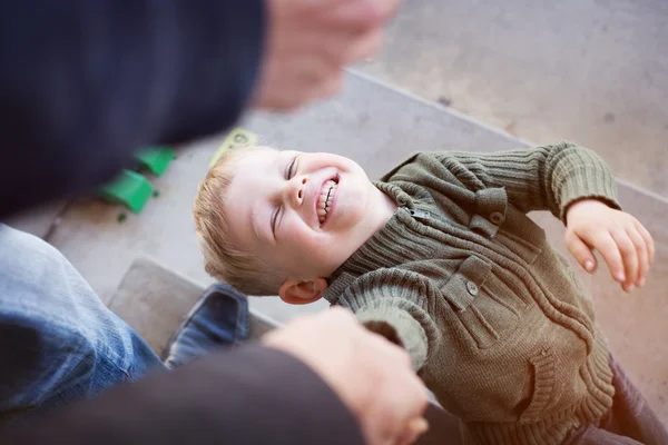 Un beau petit garçon levant les yeux vers son parent, se tenant la main — Photo