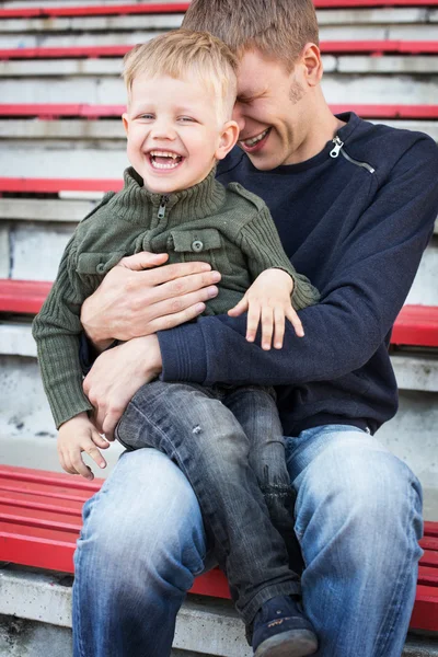 Vader en zoon lachen in leeg stadion — Stockfoto