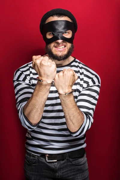 Angry burglar with handcuffs — Stock Photo, Image