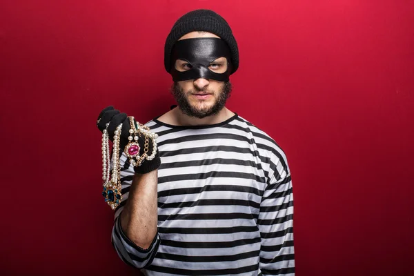 A thief holding stolen necklace — Stock Photo, Image