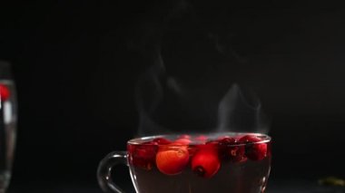 steam comes from a cup of rosehip tea, smoke illuminated by light