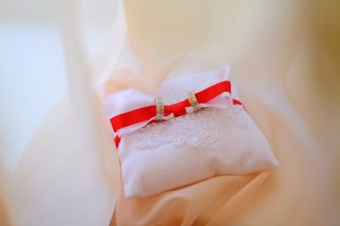 Alyans kırmızı kurdele ile minder üzerinde